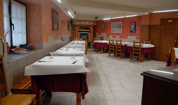 Asador El Cerco mesas y sillas en interior de restaurante